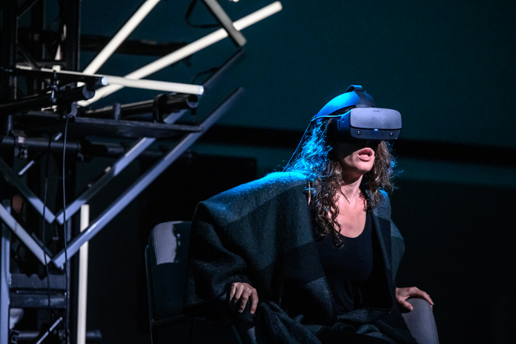 A photograph of a Tap:Ex Augmented Opera performance - a woman wears a VR headset