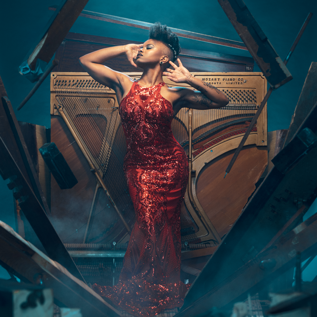 Morgan-Paige Melbourne in a red ball gown in front of a piano
